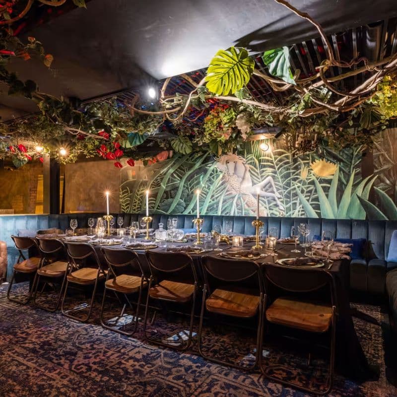 French bistro dining room with exposed beams and greenery at Loulou in Chelsea
