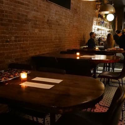 The upstairs bar area at Little More in Tribeca with its marble bar and spirit library