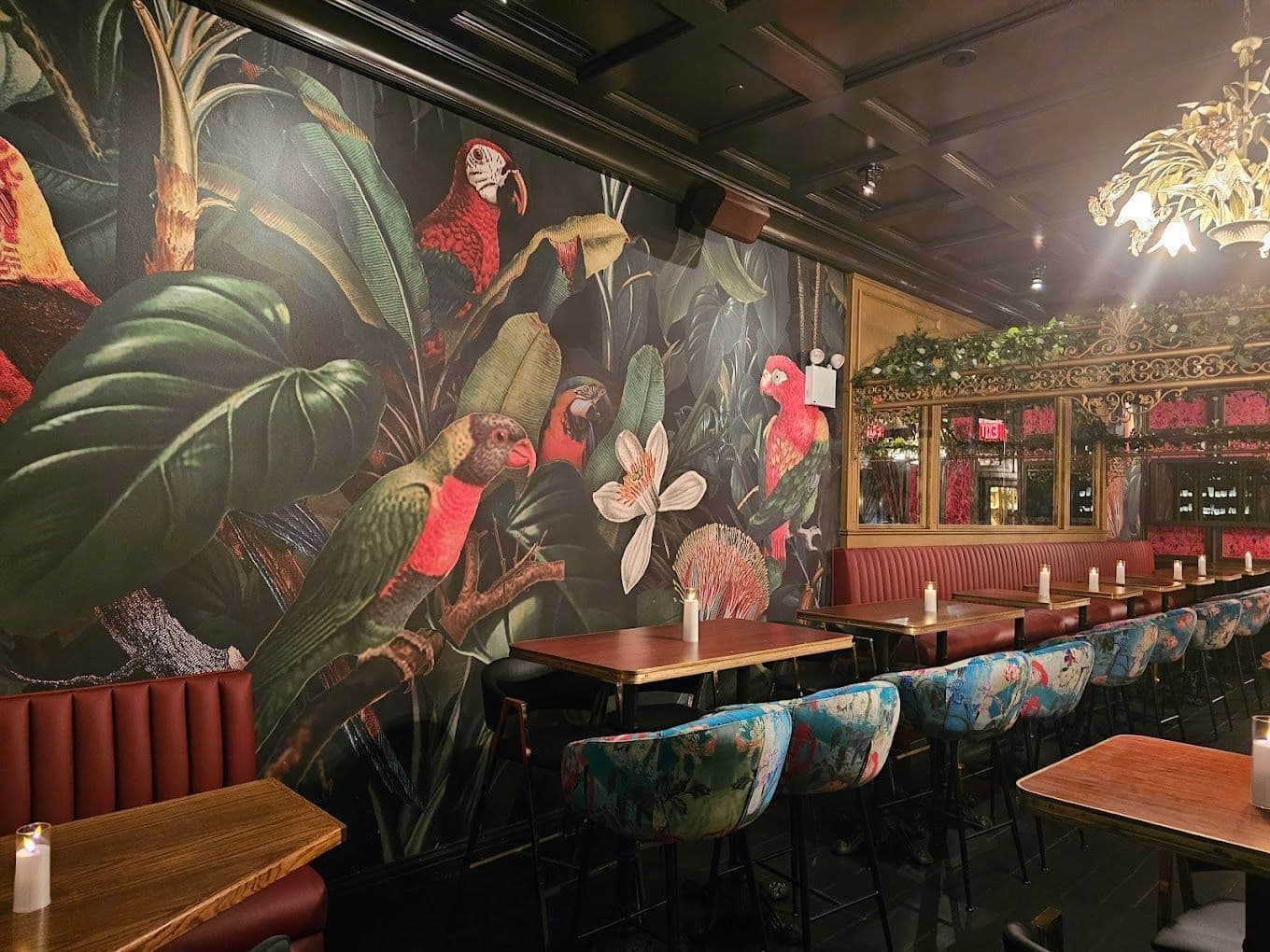 Ground floor bar at Boss Tweeds in Tribeca with red wallpaper, velvet seating, and chandeliers