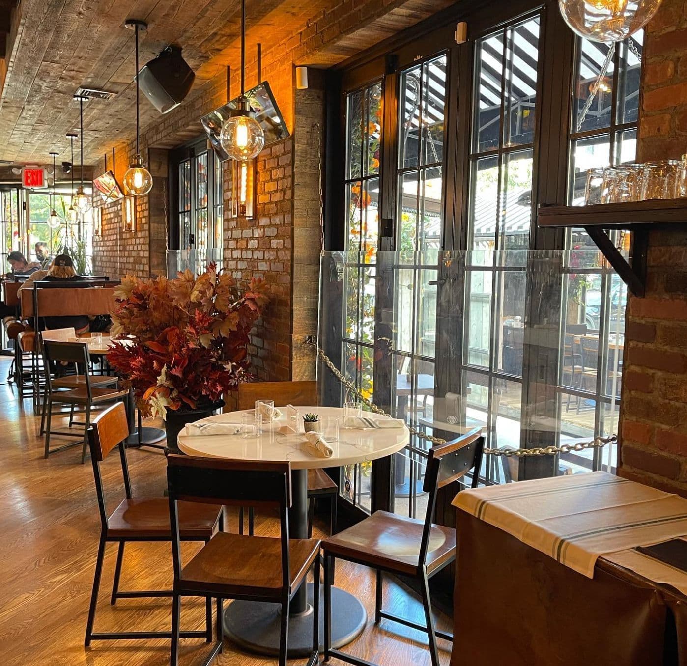 Interior of LOULOU in Chelsea, a French bistro and speakeasy with warm lighting and greenery