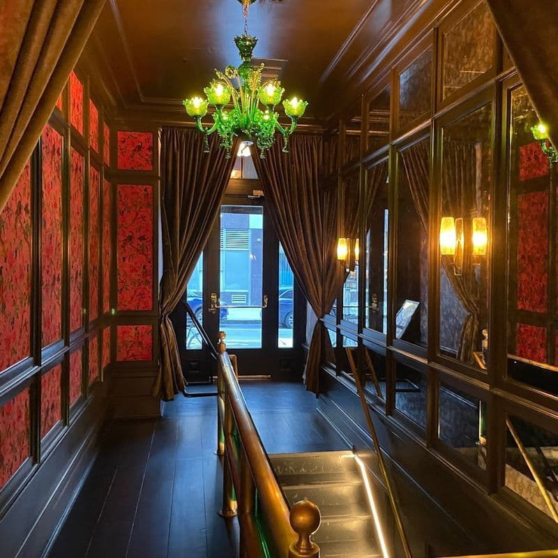 Ornate cocktail lounge with red wallpaper and gold accents at Boss Tweeds in Tribeca