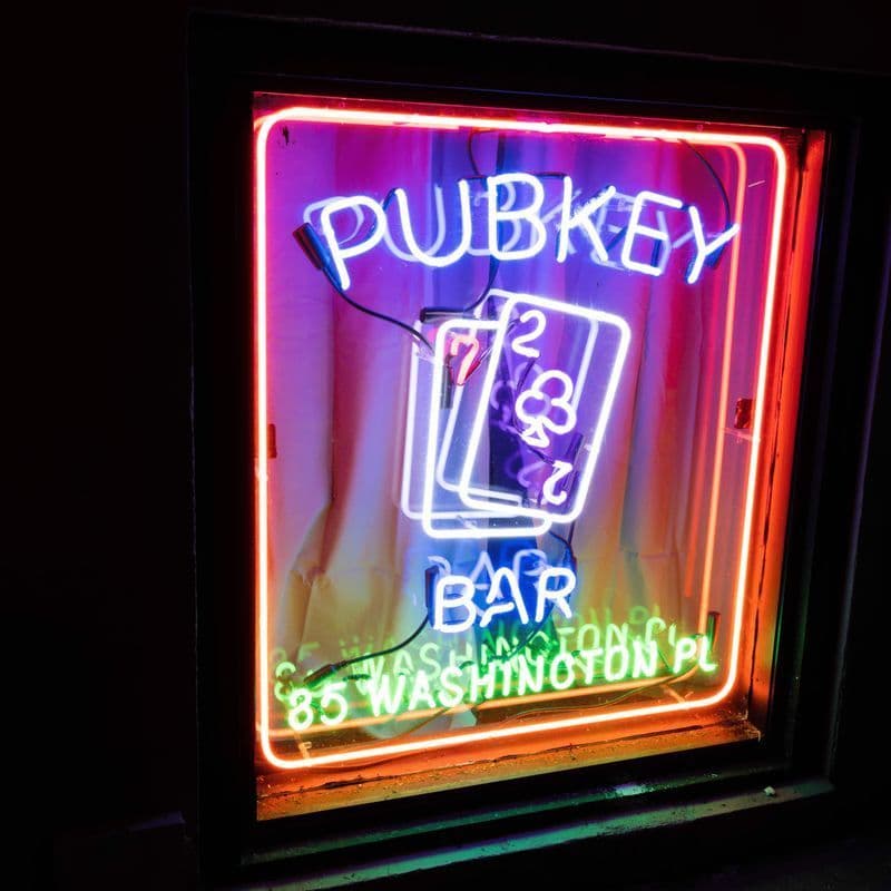 Classic dive bar interior with exposed brick and checkered floor at Pubkey in Greenwich Village