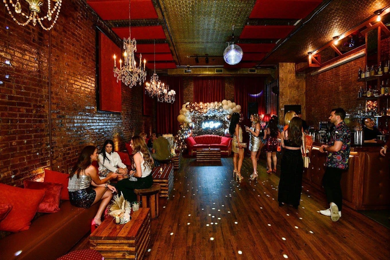 Exposed brick walls, chandeliers, and warm lighting inside Velvet Brooklyn in Williamsburg