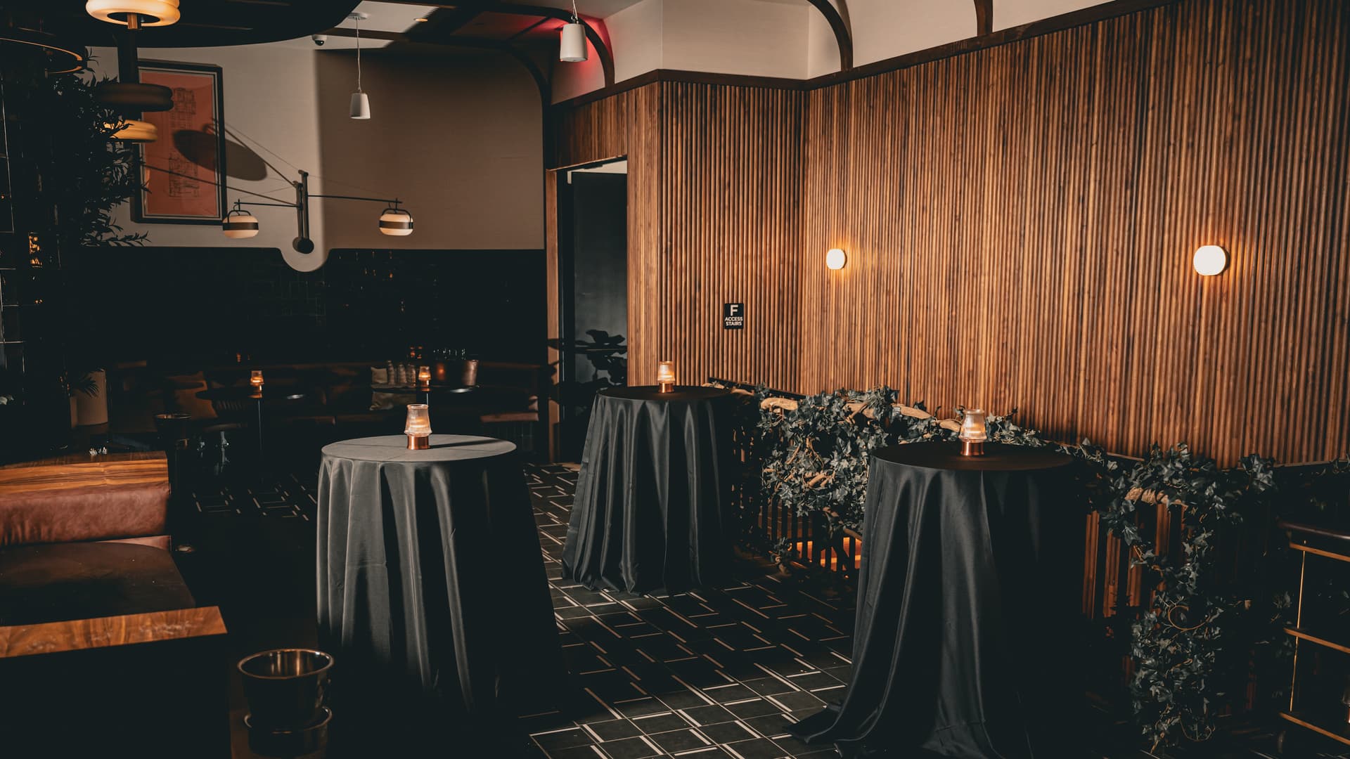 Walnut millwork and curved banquette seating inside The Alderman restaurant in Times Square