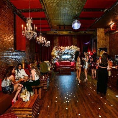 Exposed brick interior with vintage chandeliers at Velvet Brooklyn in Williamsburg