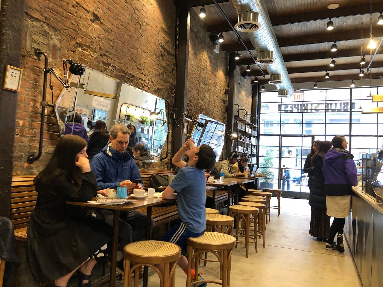 Exposed brick and floor-to-ceiling windows inside Stripes Wine Bar & Cafe