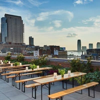 Rooftop event venue with communal tables and New York City skyline views