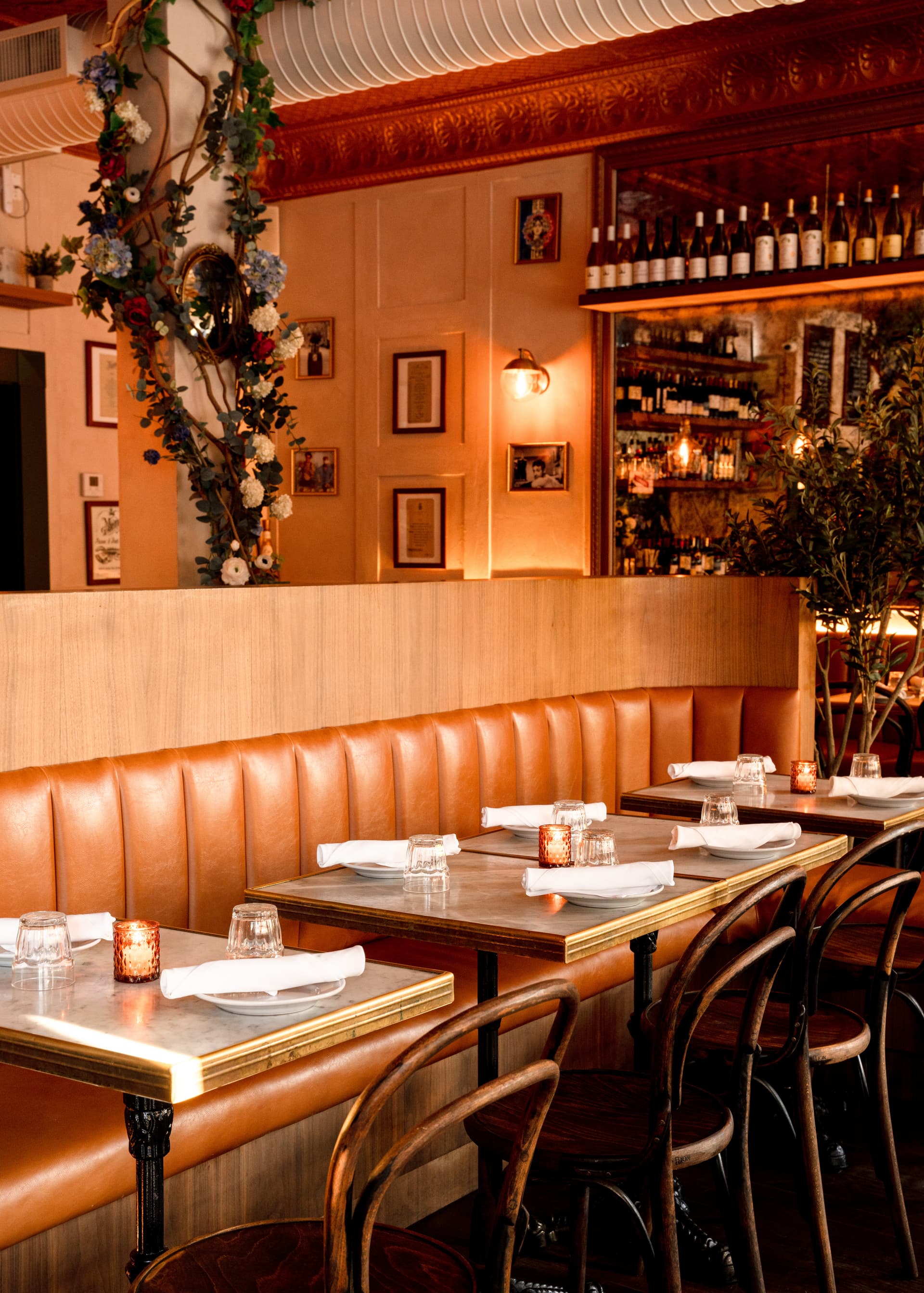 Dining room at Mino Brasserie in the West Village with zinc bar and tan banquettes