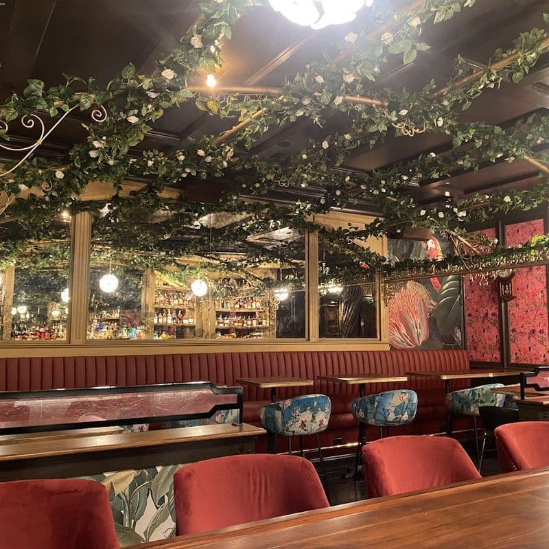 Cocktail lounge interior at Boss Tweeds in Tribeca with red wallpaper and gold accents